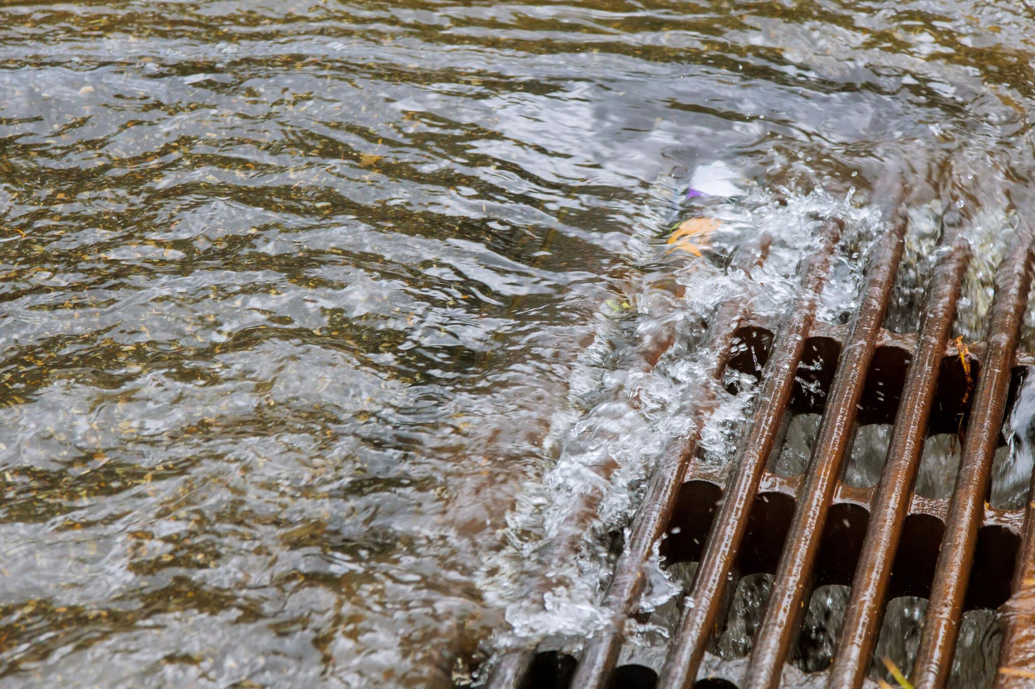 heavy rainfall draining down sewer drain