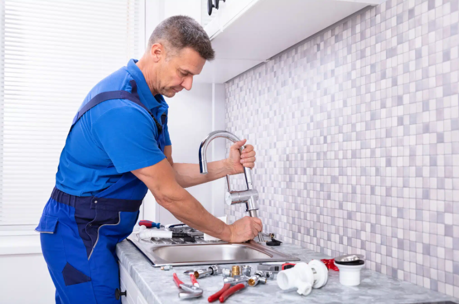 plumber installing kitchen faucet