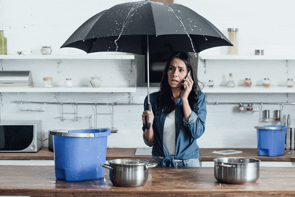 woman on phone holding umbrella in kitchen